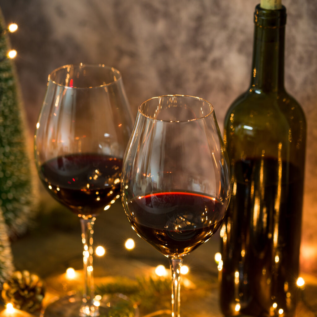 Red wine on table with Christmas lights in the background